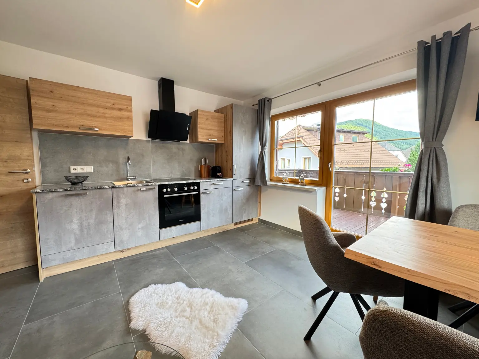 Moderne Küche im 82 m² Apartment mit Balkonzugang und Bergblick