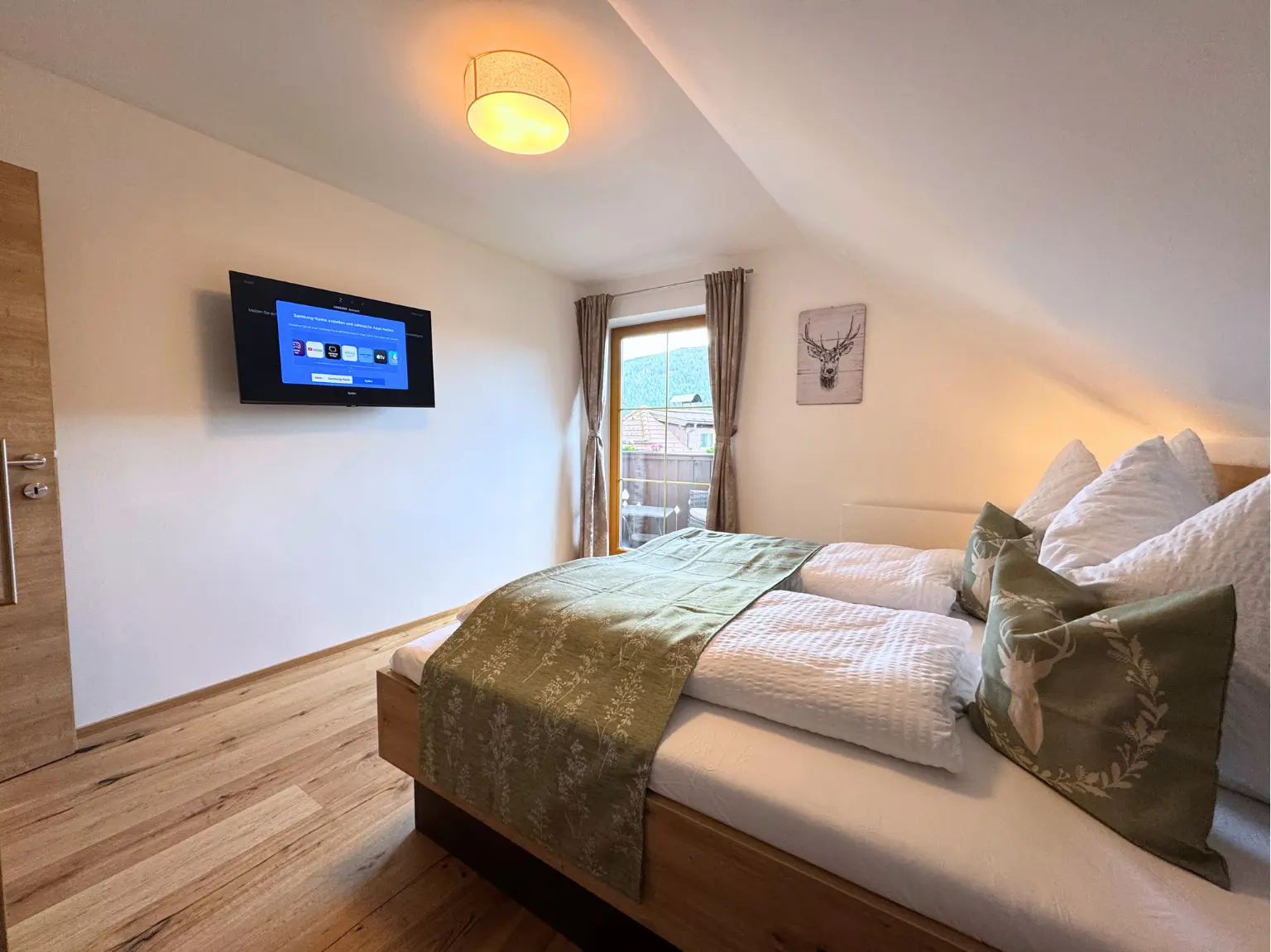 Zweites Schlafzimmer mit Doppelbett, TV und Balkonfenster