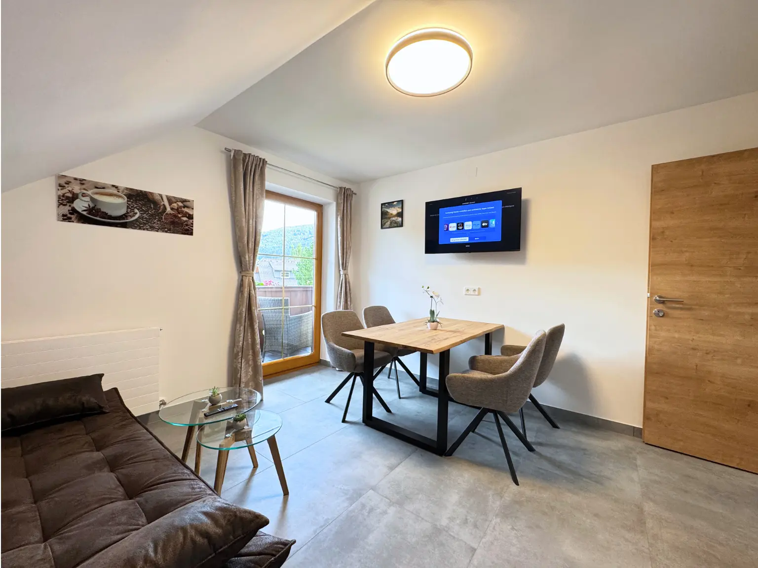 Wohn- und Essbereich im 60 m² Apartment mit Sofa, Esstisch und Balkontür