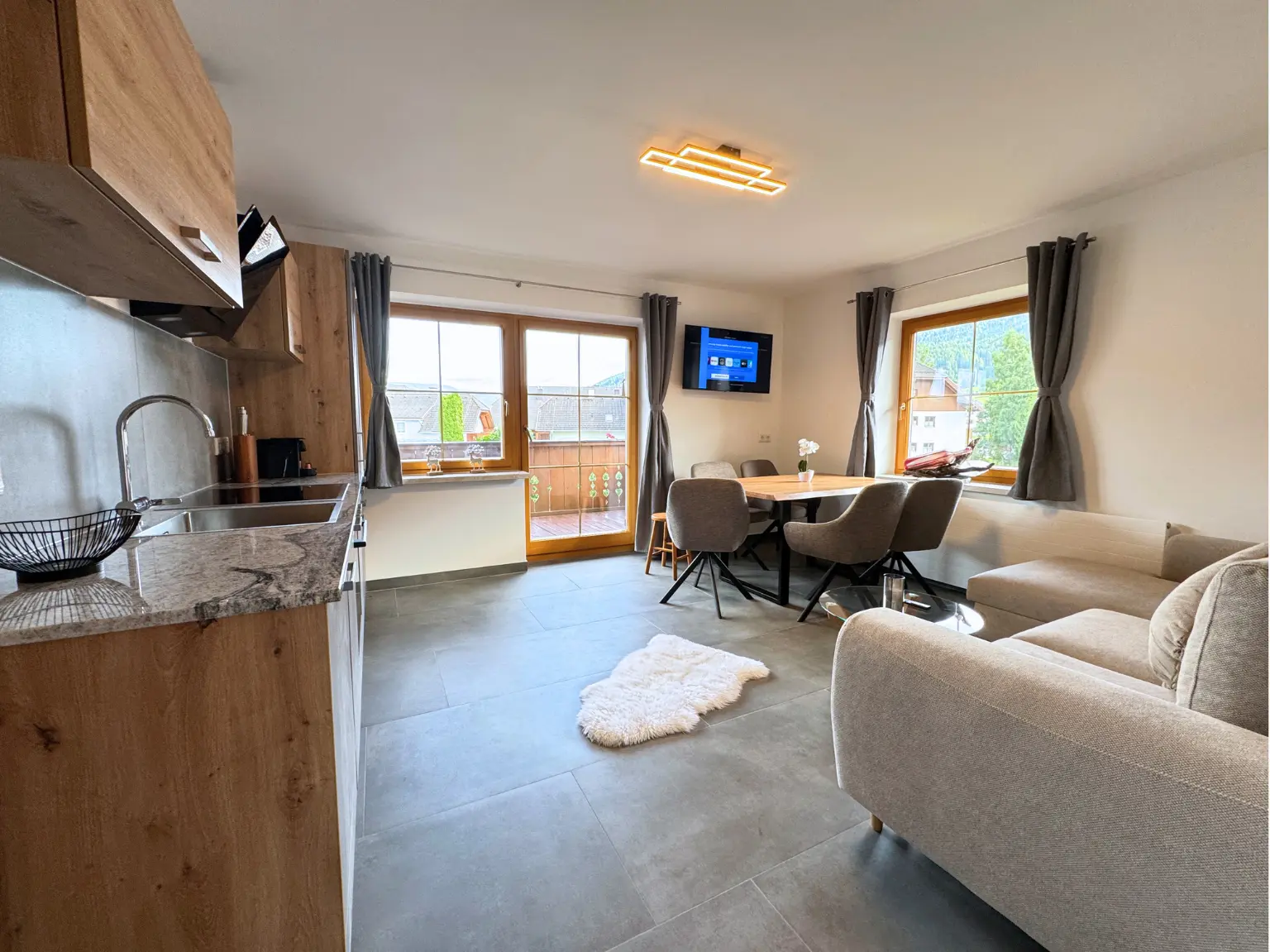 Offener Wohnbereich mit Küche, Esstisch und Sofa im 82 m² Apartment