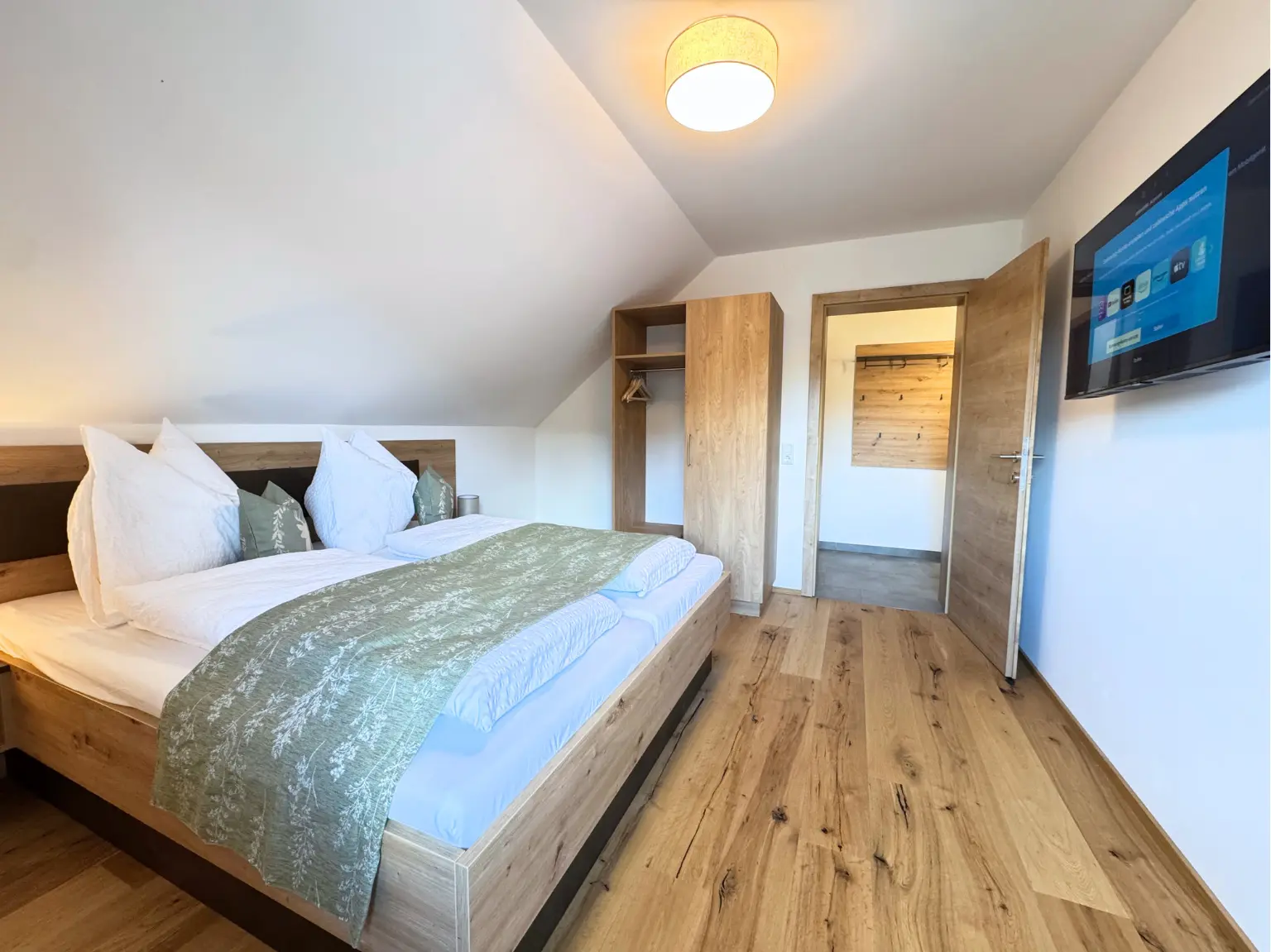 Helles Schlafzimmer mit Doppelbett und Garderobe